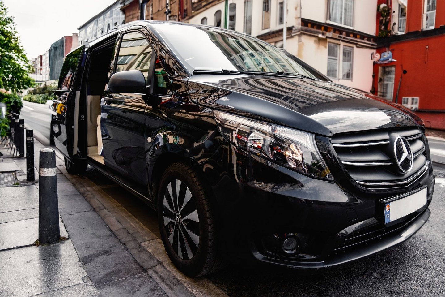 Black Mercedes-Benz V-Class with the door open, ready for guests